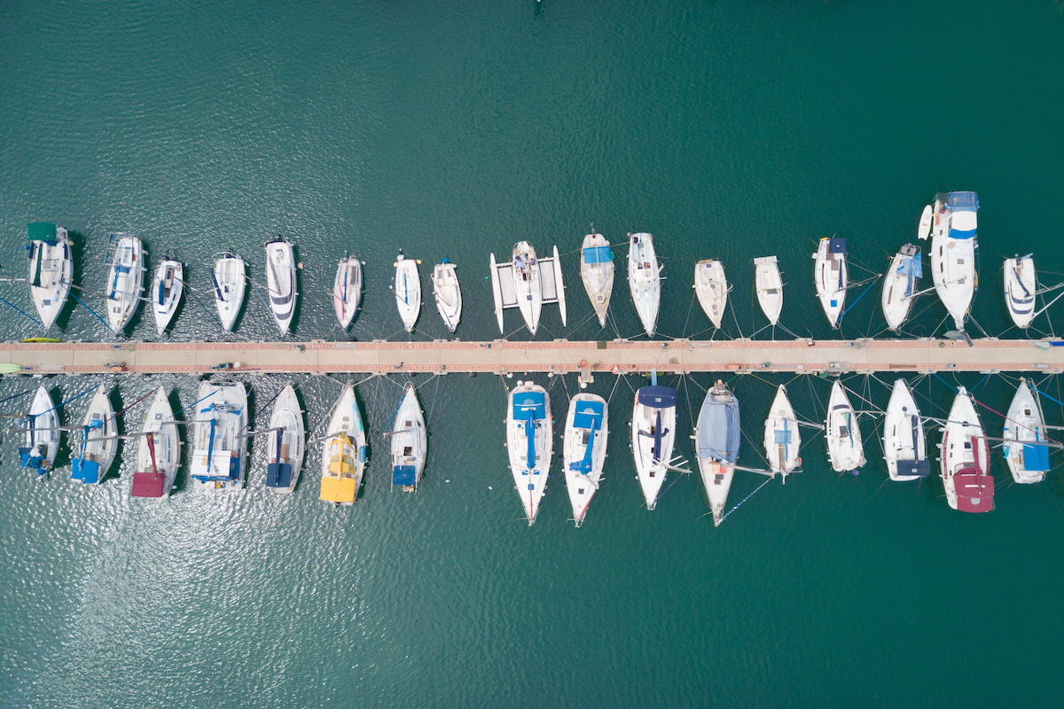An aerial shot of boats lined up at a marina. 
